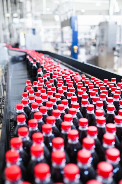 Water bottling line for processing and bottling black carbonated juice into bottles.