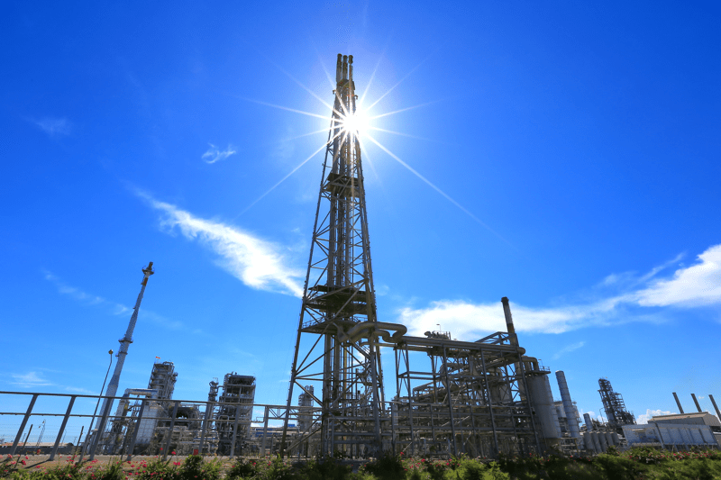 silhouette oil refinery plant against with blue sky