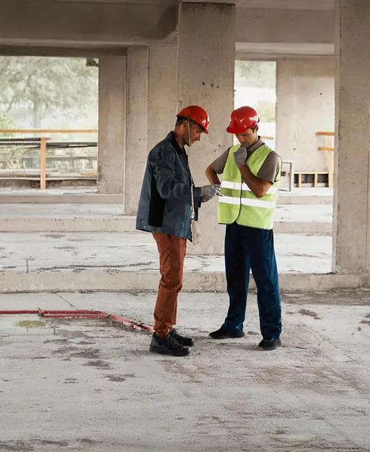 2 workers in uniform at a construction site
