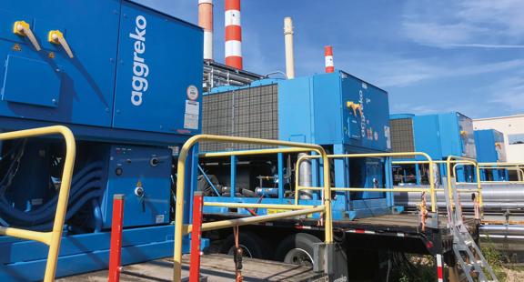 Row of blue Aggreko units outdoors, on flatbeds.