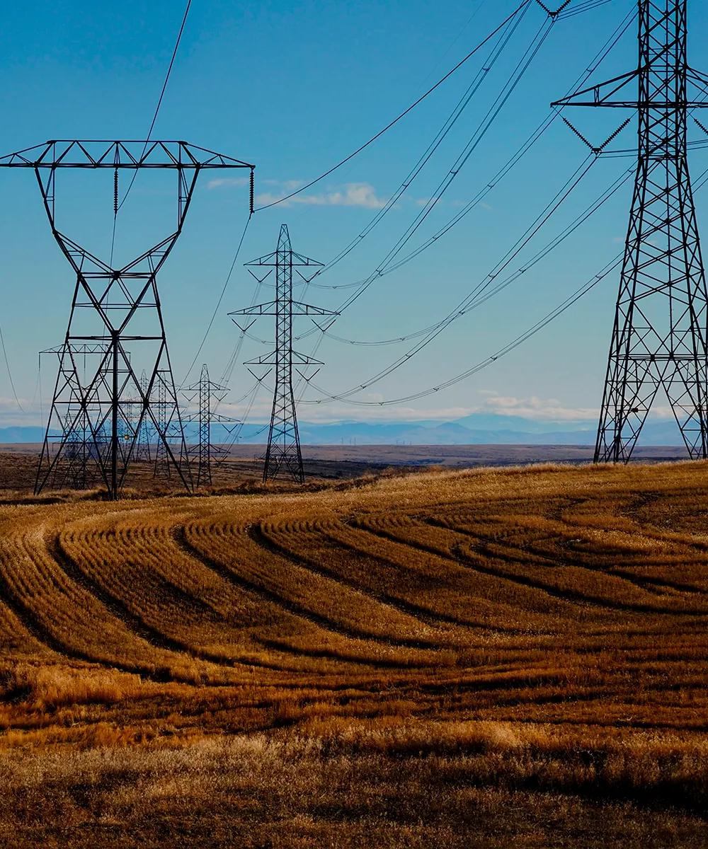Structure of a large transmission tower against a blue sky.