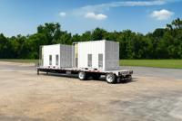 A white, containerized industrial unit sits on a flatbed trailer in a sunny, outdoor setting.