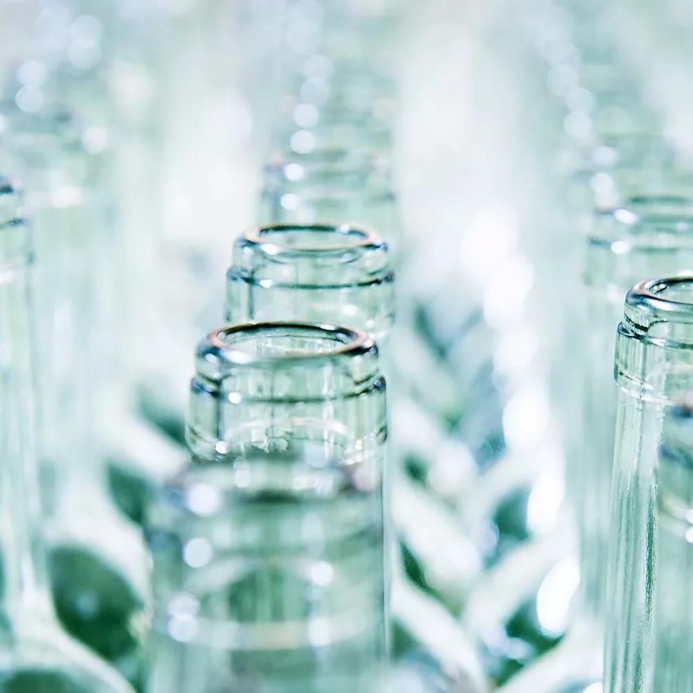 Close-up of multiple glass bottlenecks arranged in rows.