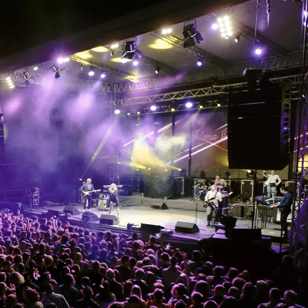 View of people in the general area of a concert watching a band play.