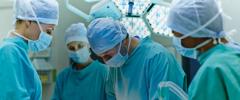 Group of surgeons performing surgery on patient in operating room