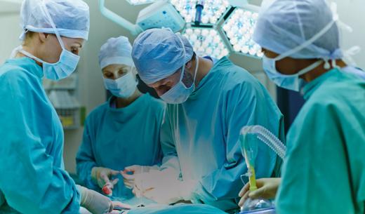 Group of surgeons performing surgery on patient in operating room