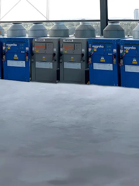Blue and black Aggreko heaters sitting outdoors