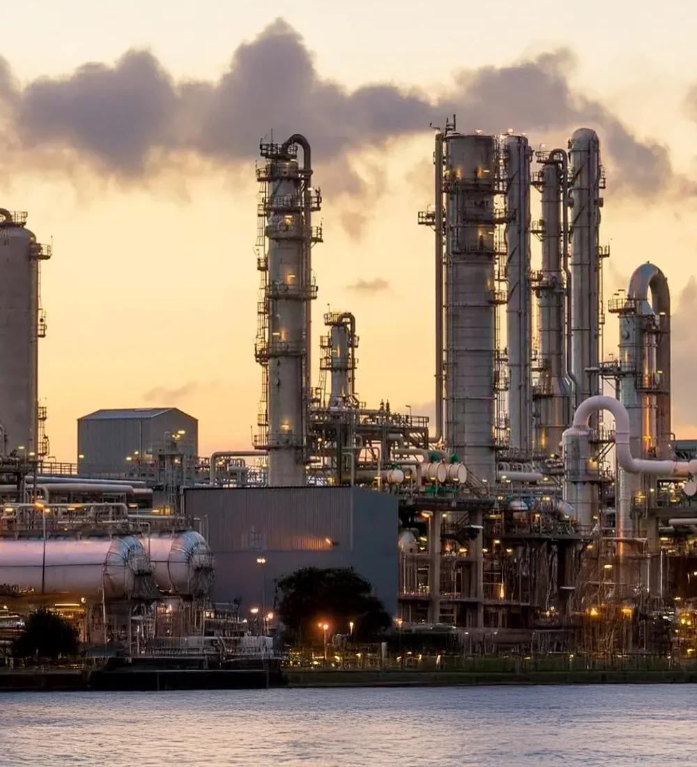 View of a refinery at a distance with a yellowish sky
