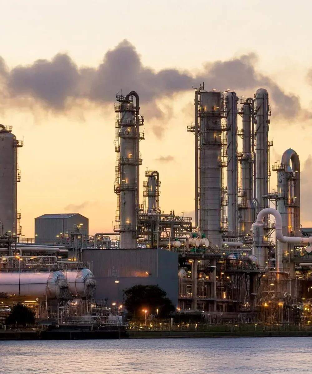 View of a petrochemical plant at dusk against a yellow sky