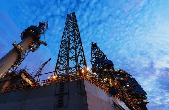 A jackup offshore oil drilling rig is docked at port for maintenance & repairs prior to reassignment.