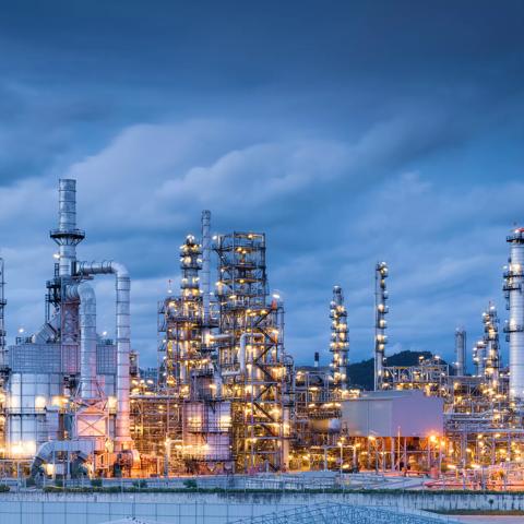 A wide view of an intricate petrochemical refinery at twilight.