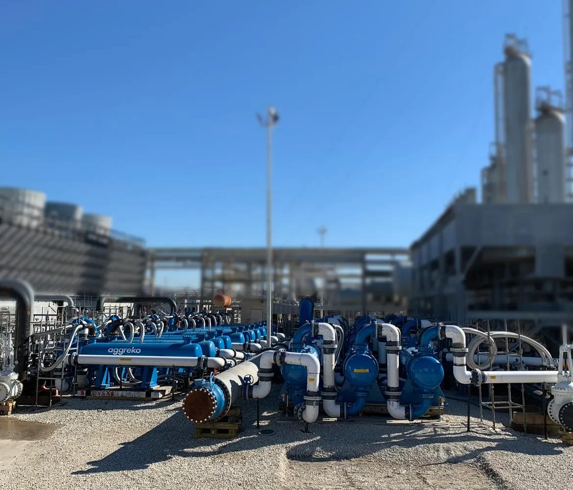 Several industrial blue and white equipment outdoors.