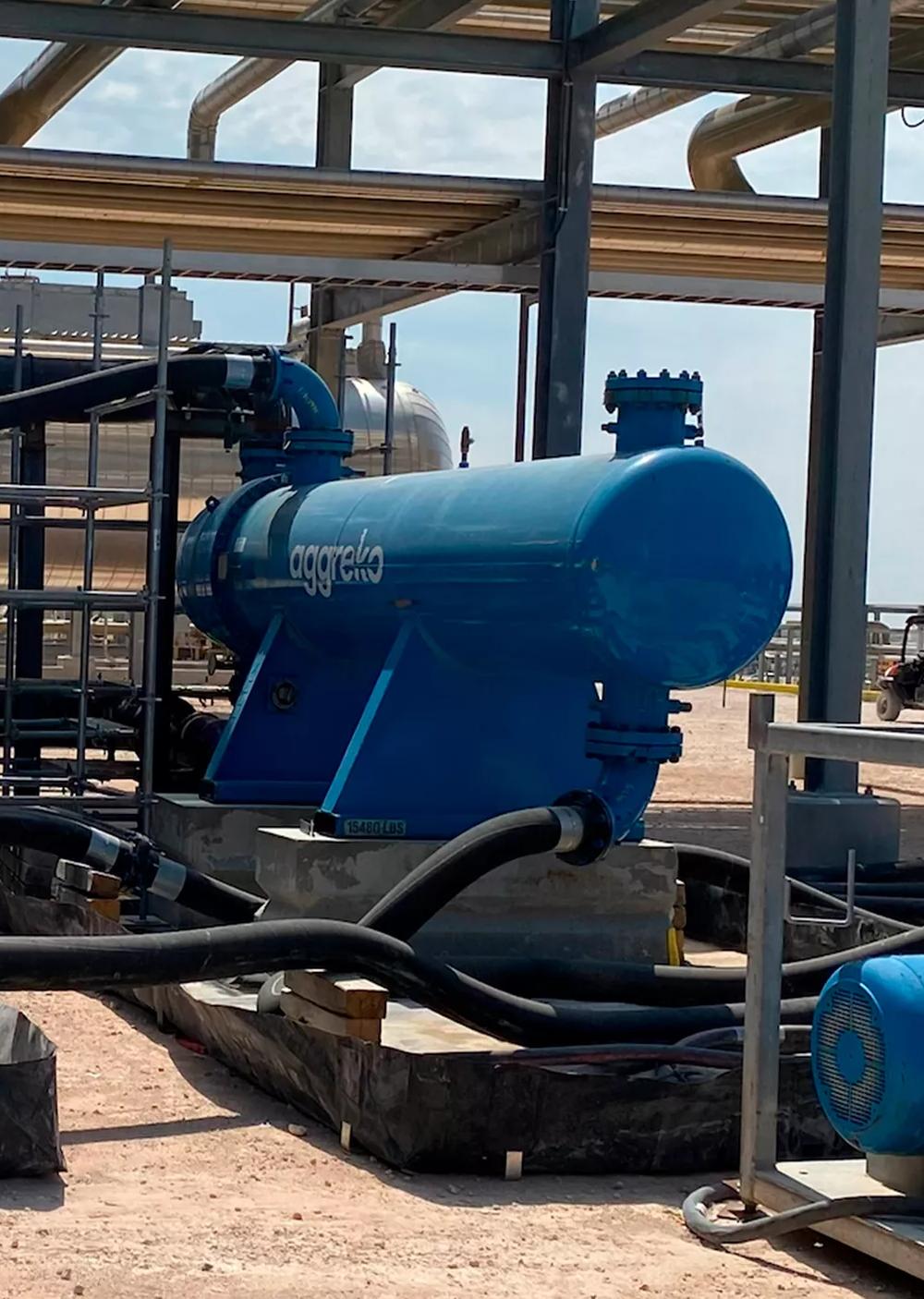 View of a large, blue industrial unit with industrial machinery is visible in the background.