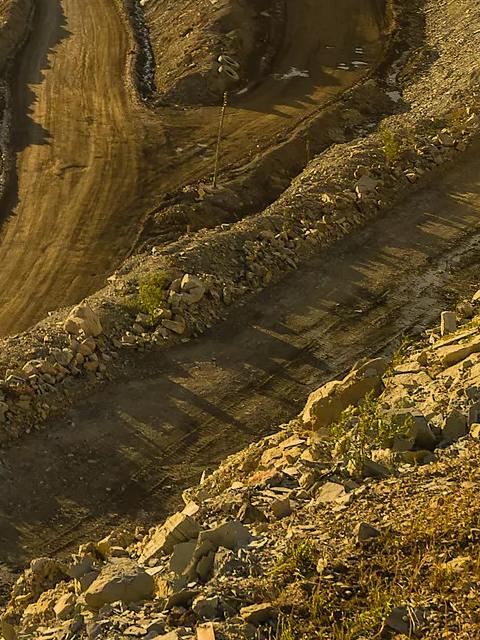 Une vue aérienne d'un grand site d'excavation, avec des chemins de terre.