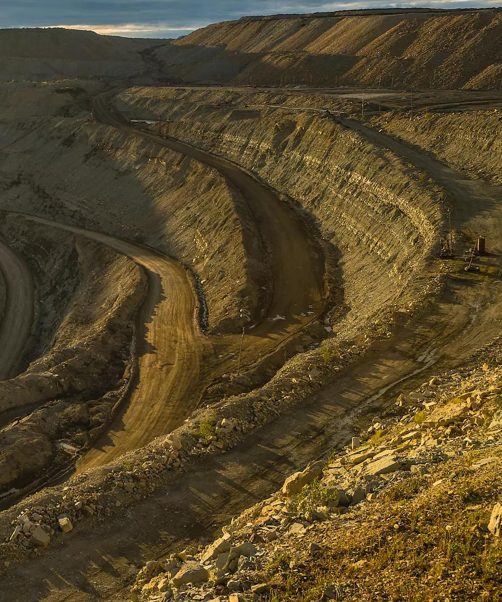 An aerial view of a large excavation site, with dirt roads.