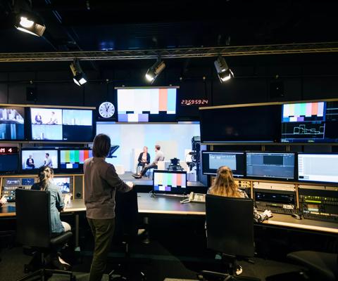 A group of university students working in a tv studio and learning how to use the equipment.