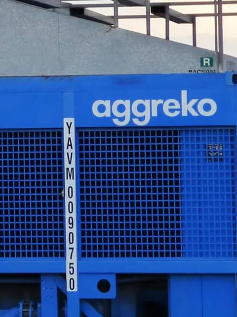 Industrial equipment and blue Aggreko units at a work site.