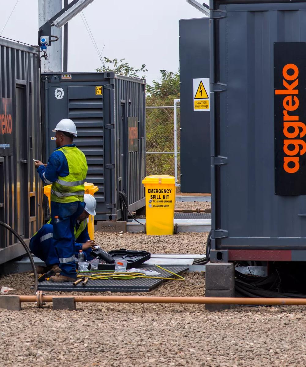 Technicians alongside generator