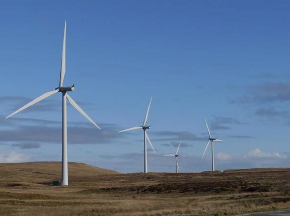 Wind turbines in field at twilight