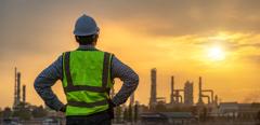 Asian engineers looking at site in oil and gas refinery or Petrochemical factory during sunrise, industrial concept.