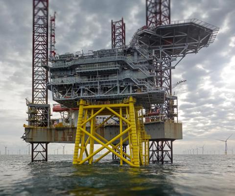 View on offshore wind-farm with 8MW wind-turbines and offshore platform in German north Sea with dramatic clouds