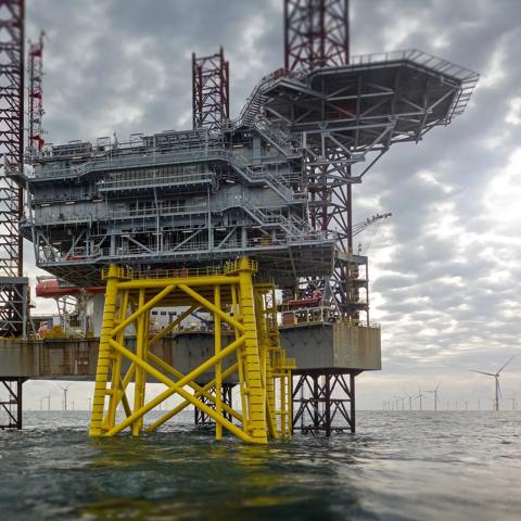 View on offshore wind-farm with 8MW wind-turbines and offshore platform in German north Sea with dramatic clouds