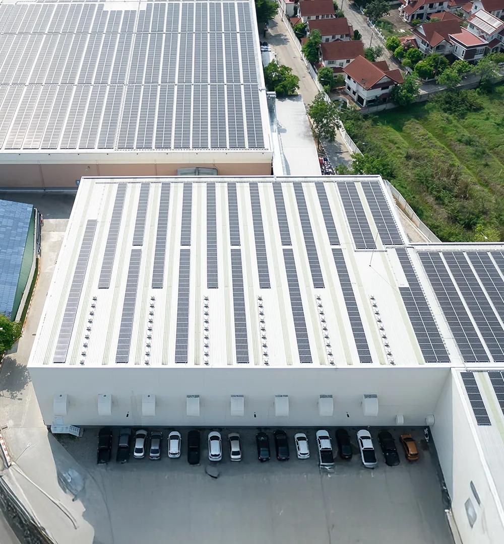 Aerial view of industrial warehouse buildings with rooftop solar panels installed.