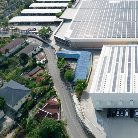 Aerial view of industrial warehouse buildings with rooftop solar panels installed.