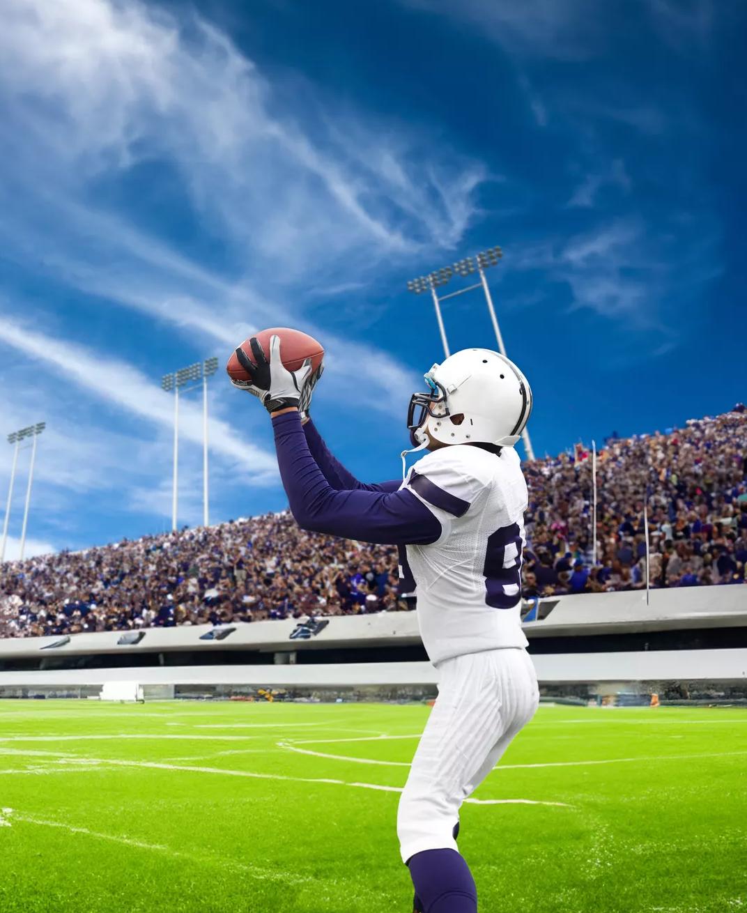 Ground shot of a football player catching the football.