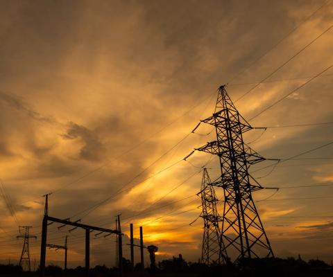 Electrical Grid and Transmission Line at Dusk. Electricity Pylons Against Sky at Sunset. Clouds Moving Across Sky.  Ecology concept