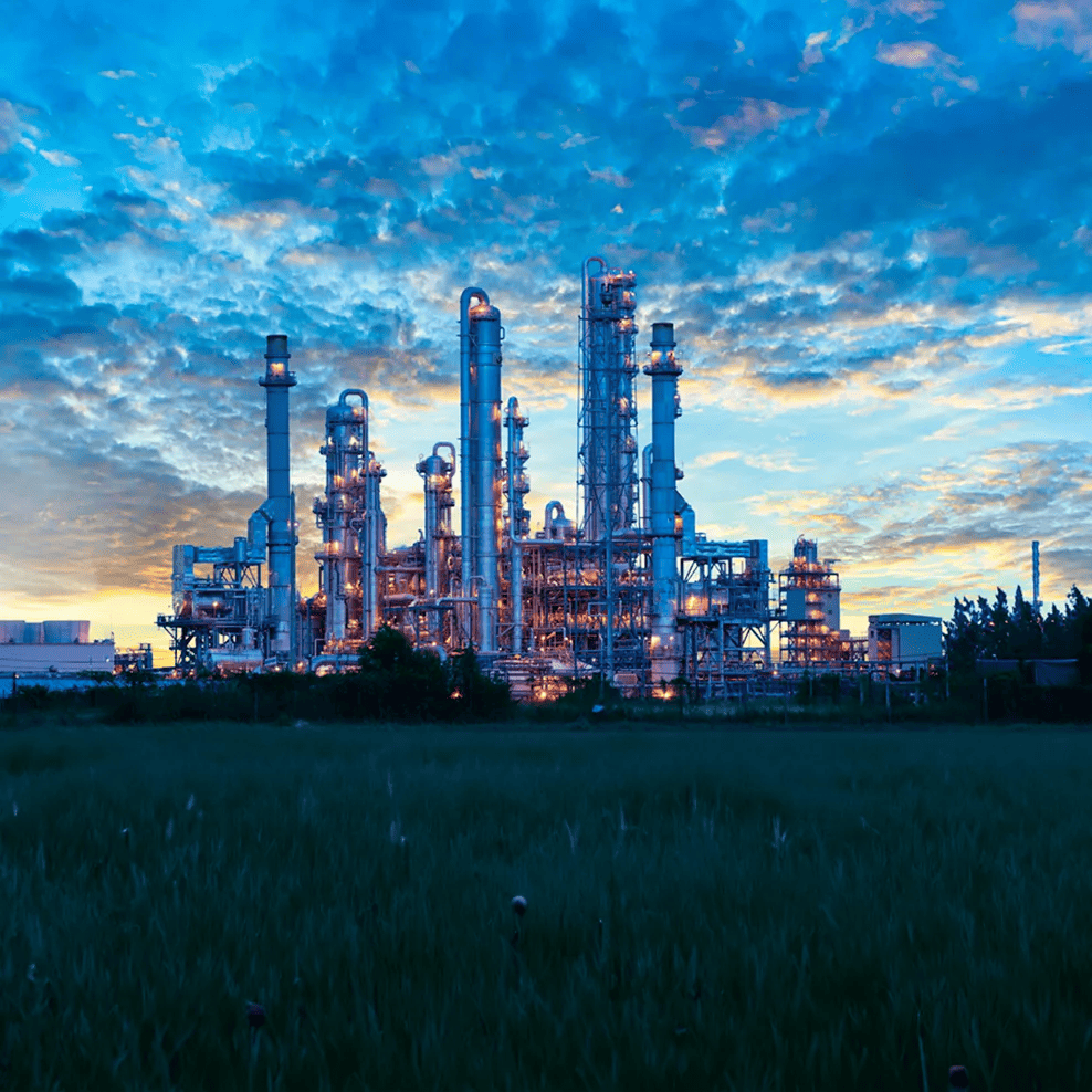 Panoramic view of a petrochemical plant at twilight against a cloudy sky
