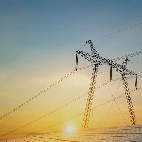 View of a transmission tower with the Sun in the background
