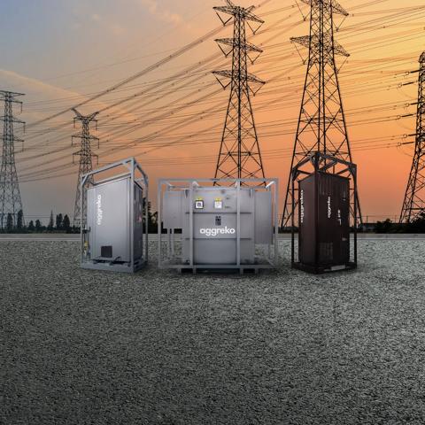 3 Aggreko industrial units outdoors with transmission towers in the background.