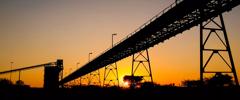 Silhouette of a mining silo and conveyor belts at sunset on a Palladium Platinum Mine