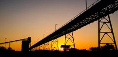 Silhouette of a mining silo and conveyor belts at sunset on a Palladium Platinum Mine