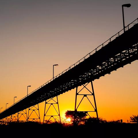 Silhouette of a mining silo and conveyor belts at sunset on a Palladium Platinum Mine