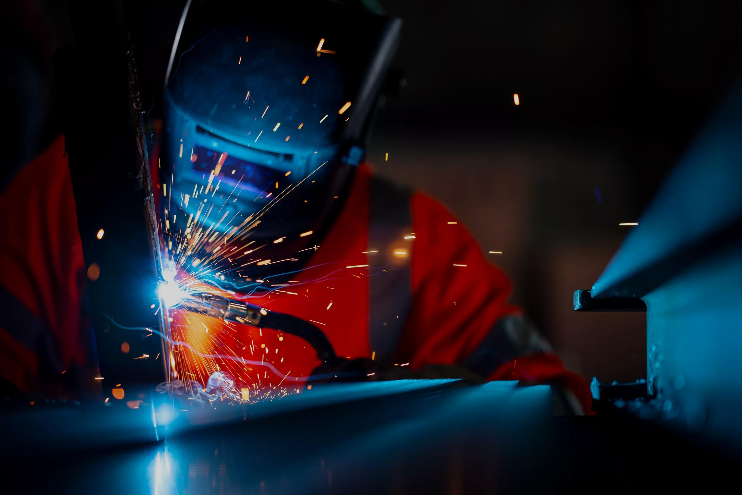 Structural Welding, Welding Engineering. African American welders use carbon arc welding torches for spot welding of a construction beam in the construction industry.