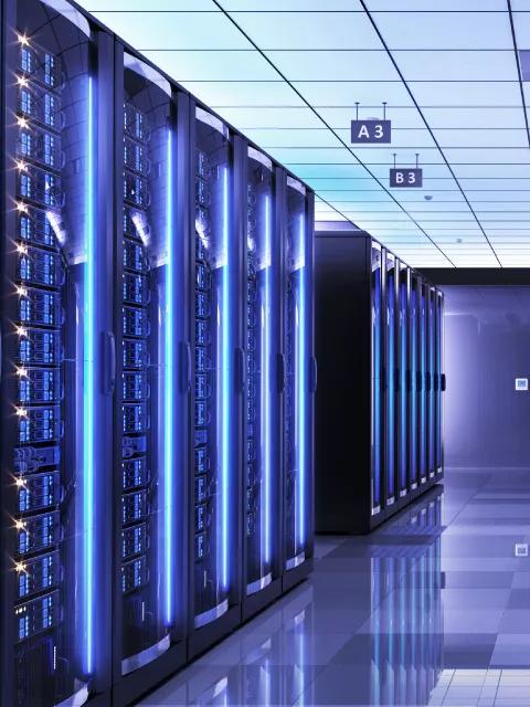 Hallway with glass and blue lights inside a data center
