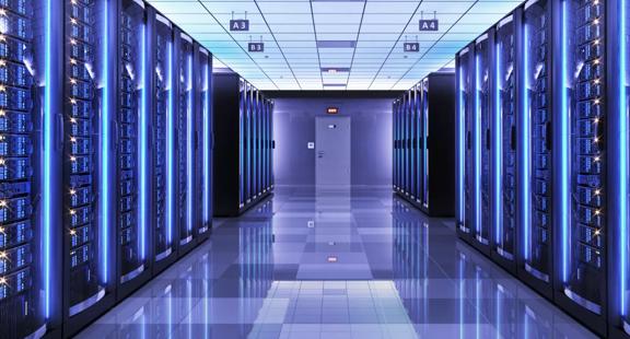 View of a data center room with multiple server racks on the sides.