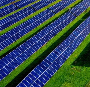 Aerial view of multiple diagonal rows of solar panels. 