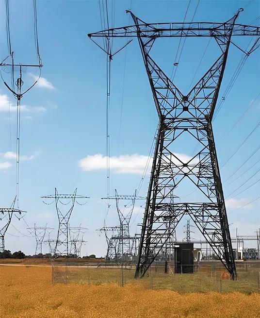 Structure of a large transmission tower against a blue sky.
