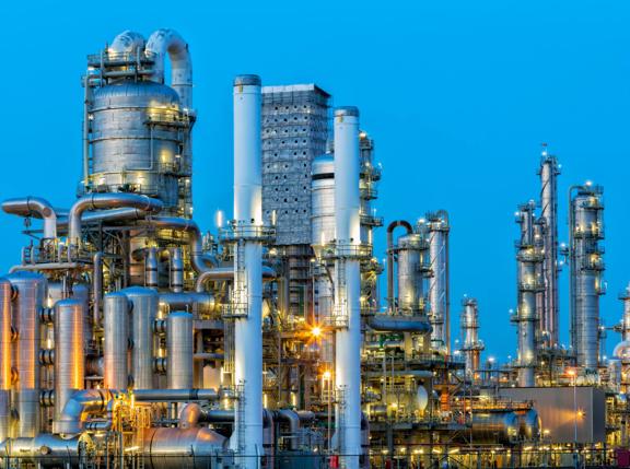 A large, modern petrochemical plant at dusk in industrial district near Rotterdam, Netherlands, Benelux, Europe. Many chimneys, tanks, distillation towers and other installations are visible against blue sky. 50 megapixel HDR image taken with Canon EOS 5Ds, digital blending technique, long exposure with tripod.