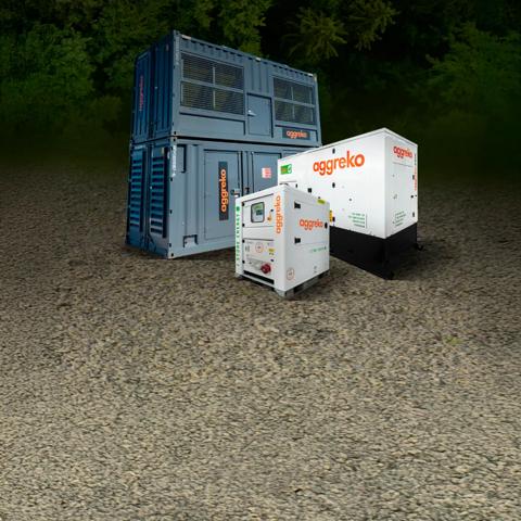 Three Aggreko power units placed in front of a green, tree-filled background.
