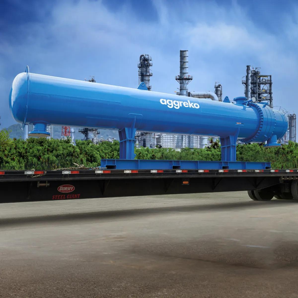 A large, cylindrical blue Aggreko industrial vessel mounted horizontally on a flatbed trailer.