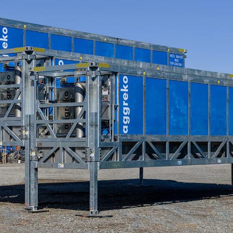 A close-up view of three gray modular frames holding blue industrial Aggreko container units.