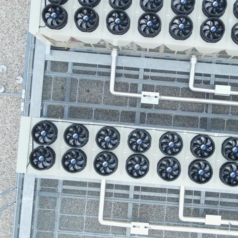 top-down view of a rooftop installation featuring industrial HVAC systems alongside solar panels.