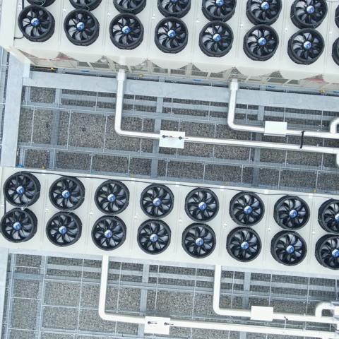 top-down view of a rooftop installation featuring industrial HVAC systems alongside solar panels.