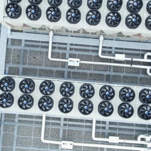 top-down view of a rooftop installation featuring industrial HVAC systems alongside solar panels.