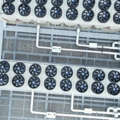 top-down view of a rooftop installation featuring industrial HVAC systems alongside solar panels.