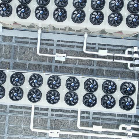 top-down view of a rooftop installation featuring industrial HVAC systems alongside solar panels.